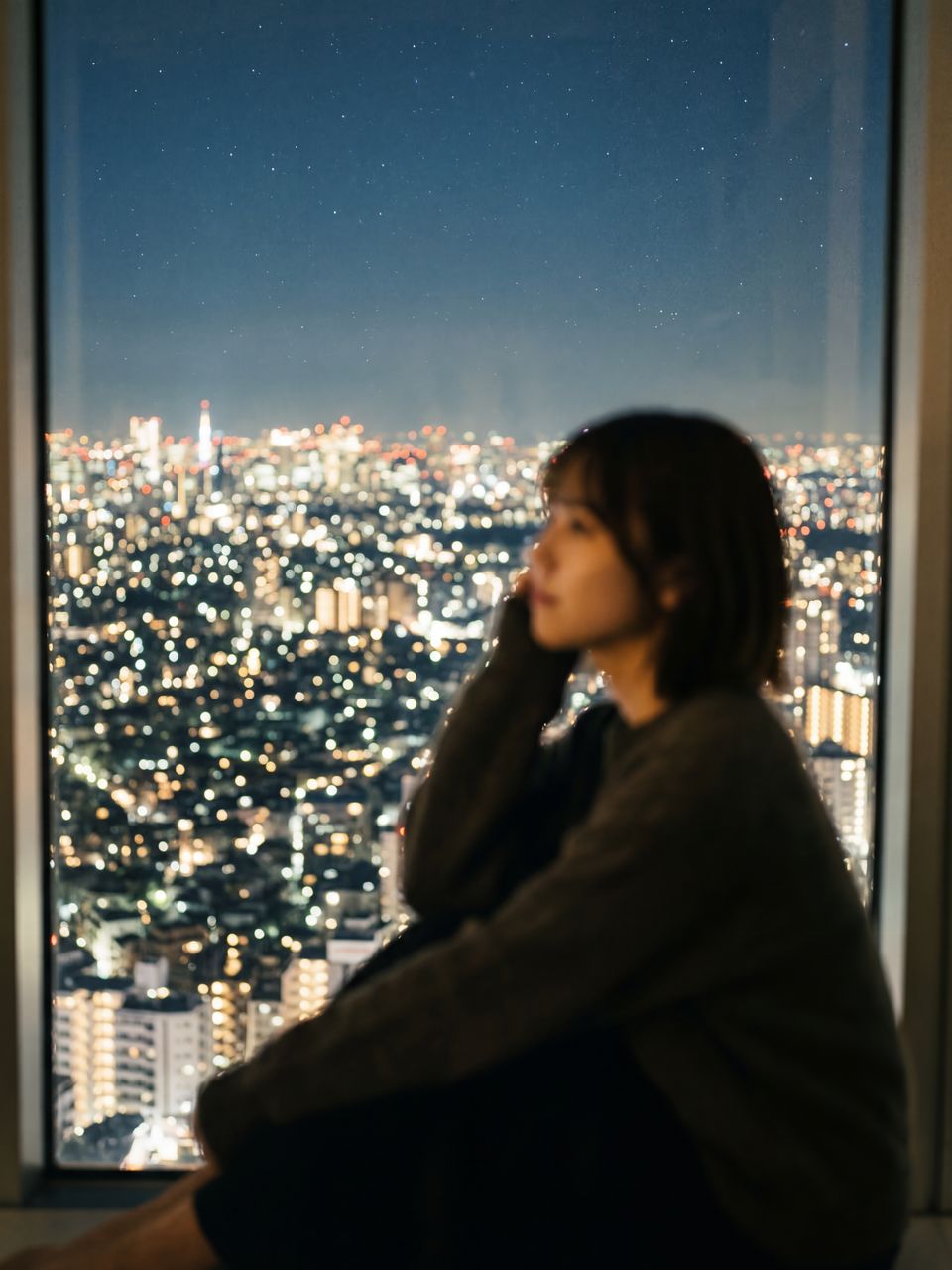 夜の窓から見える静かな街の灯り