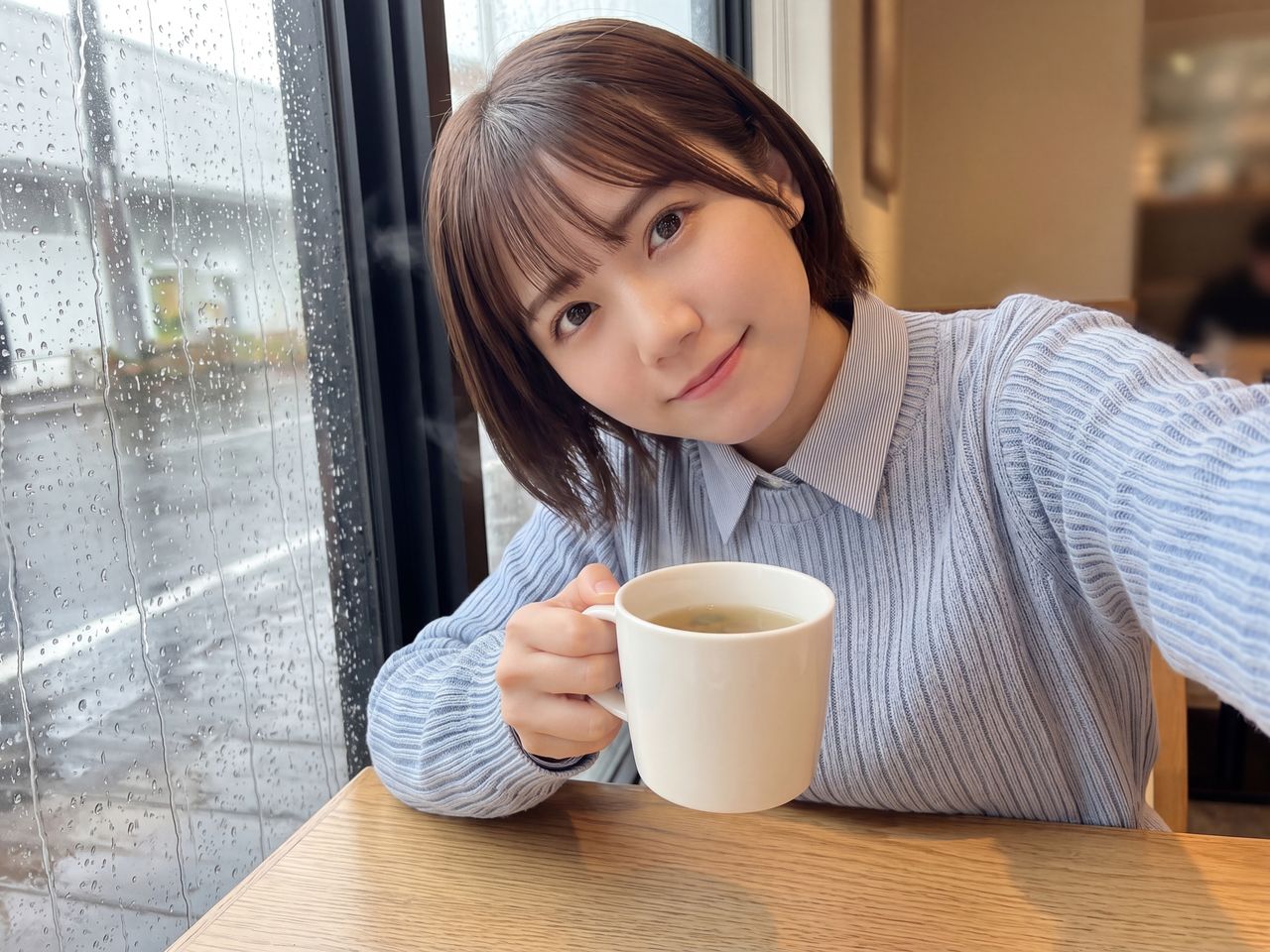 ハーブティーのマグカップを両手で包み込んで微笑む天音かなで