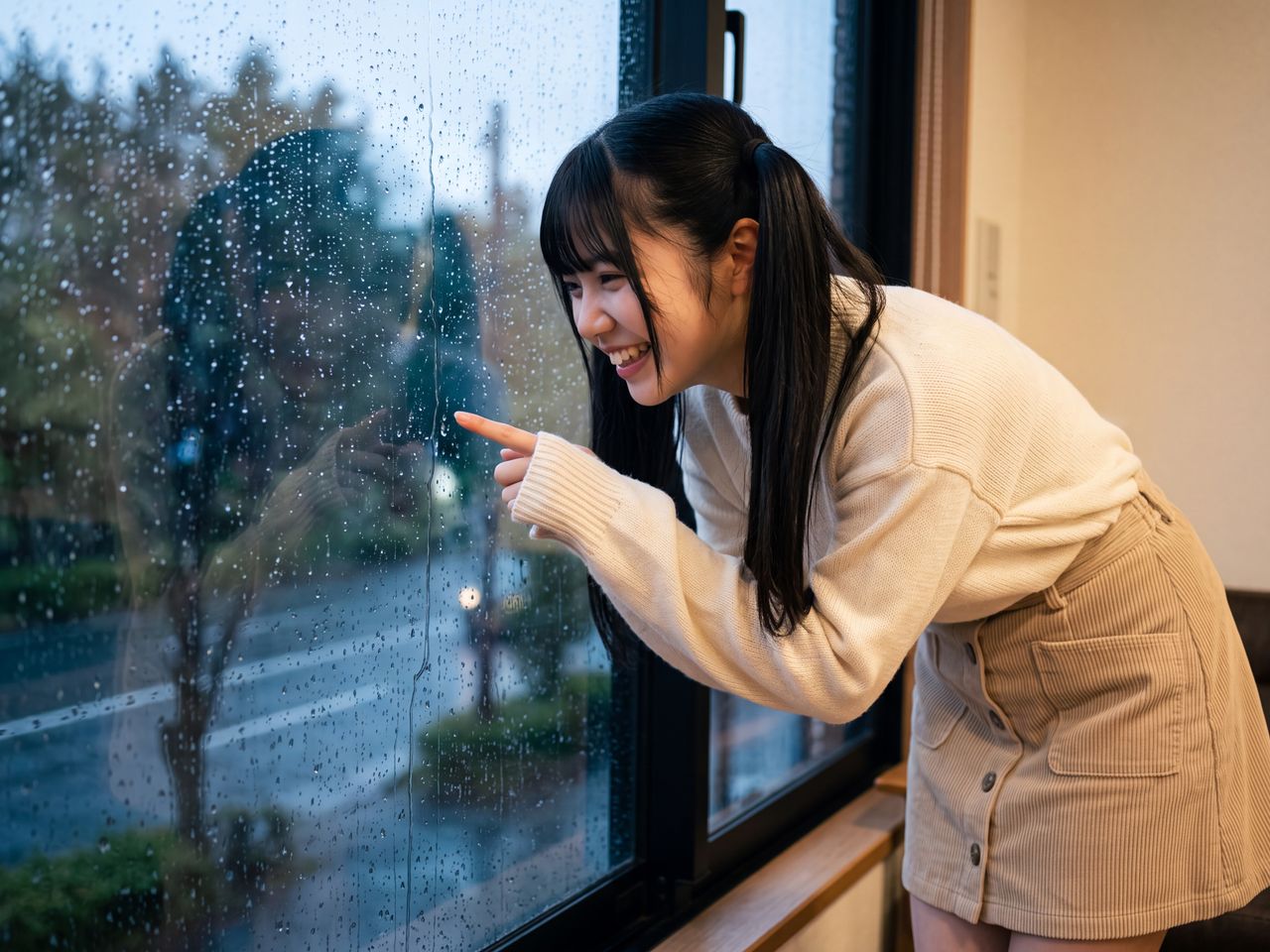 窓のしずくを指差して見つめる葉月柚子