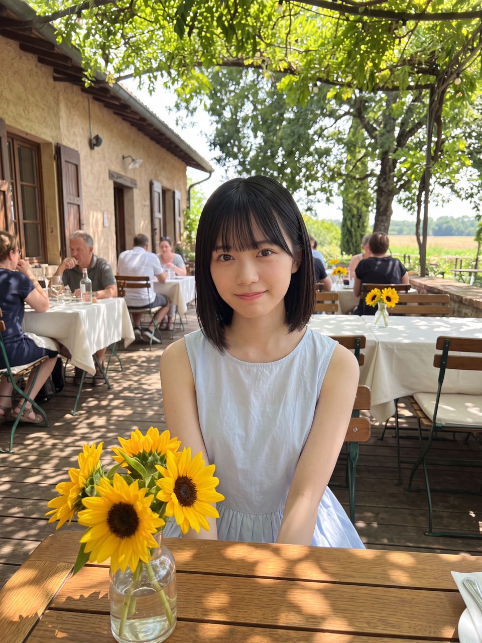向日葵の飾られたテラスで微笑む小鳥遊ひな