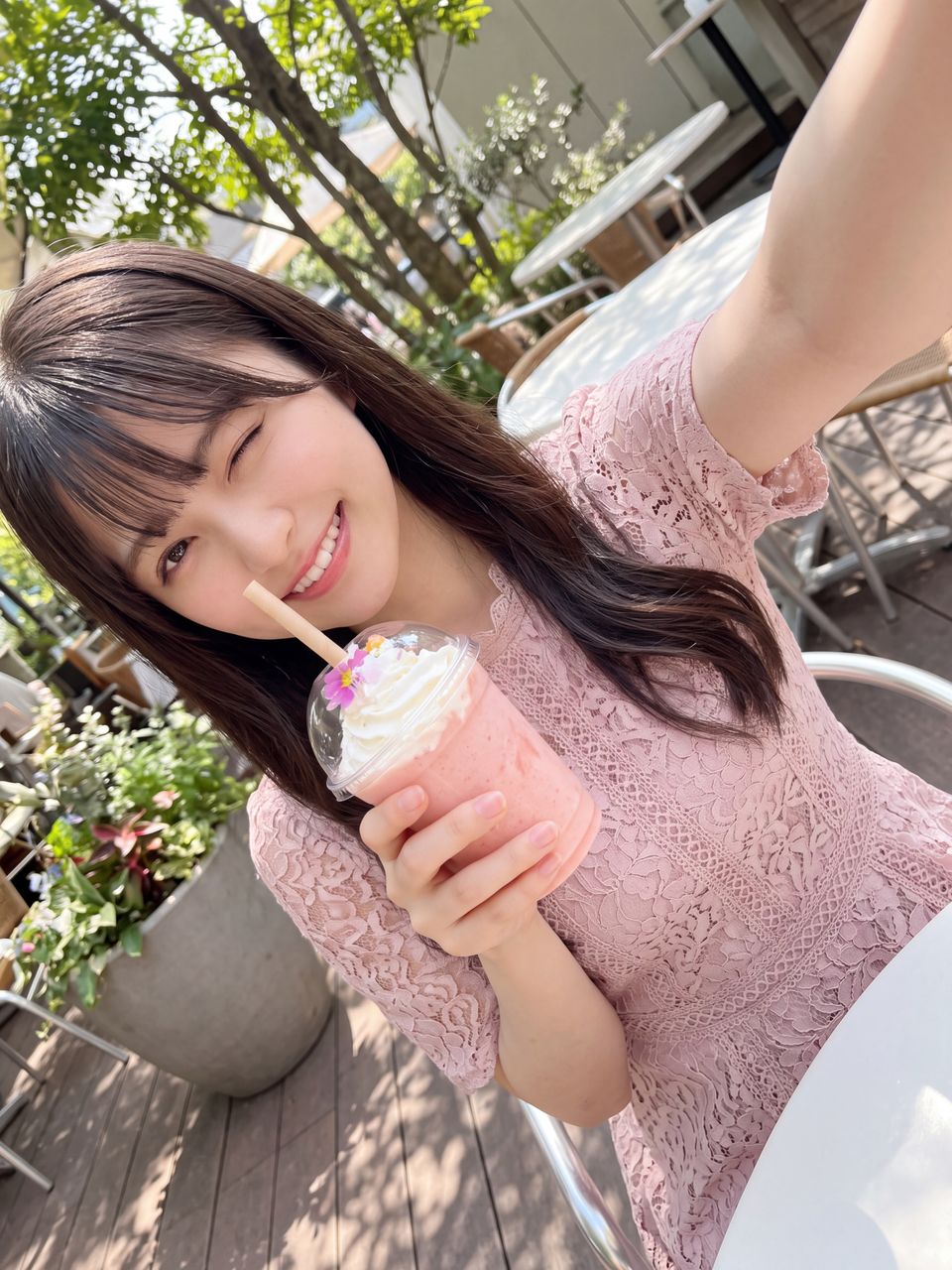 カフェのテラス席でピンクの桃スムージーを持ち自撮りする姫宮桃