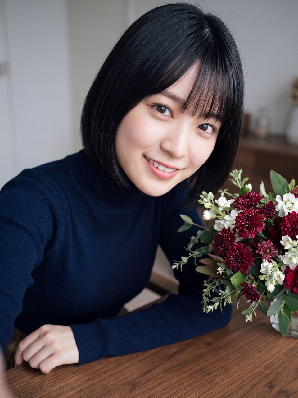 メンバーから贈られた秋の美しいフラワーブーケの傍らで少し照れくさそうに温かい笑顔を浮かべる星野美月の自撮り写真