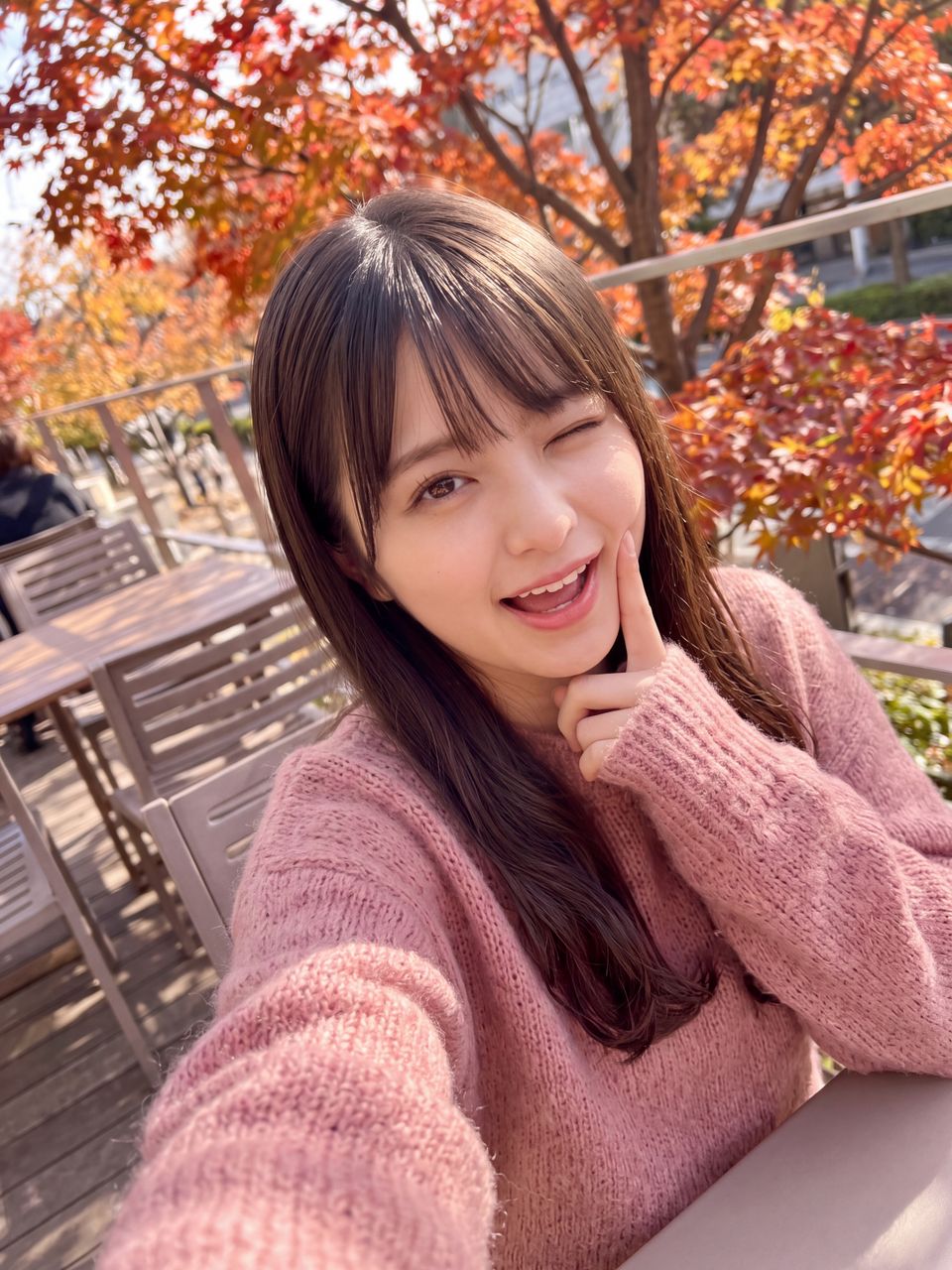 秋のテラスカフェで人差し指を頬に当て特大ウインクを決める姫宮桃のあざと可愛い自撮りショット